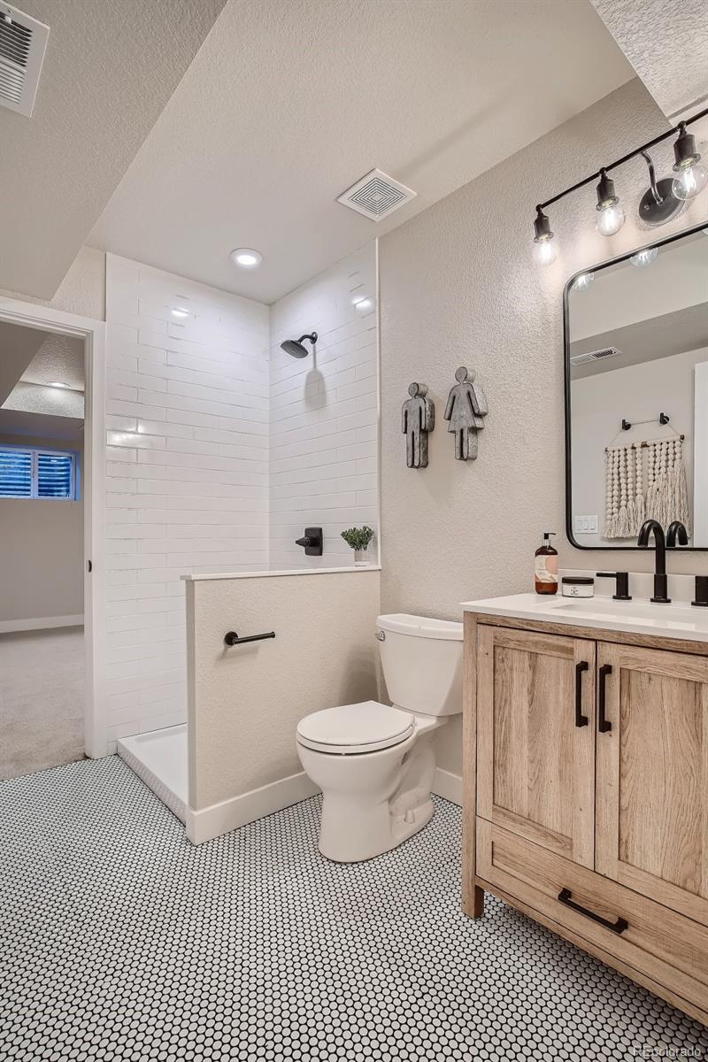 3806 Simms Court Wheat Ridge, CO 80033 - Photo 23 of 30 a bathroom with a sink a toilet and a mirror
