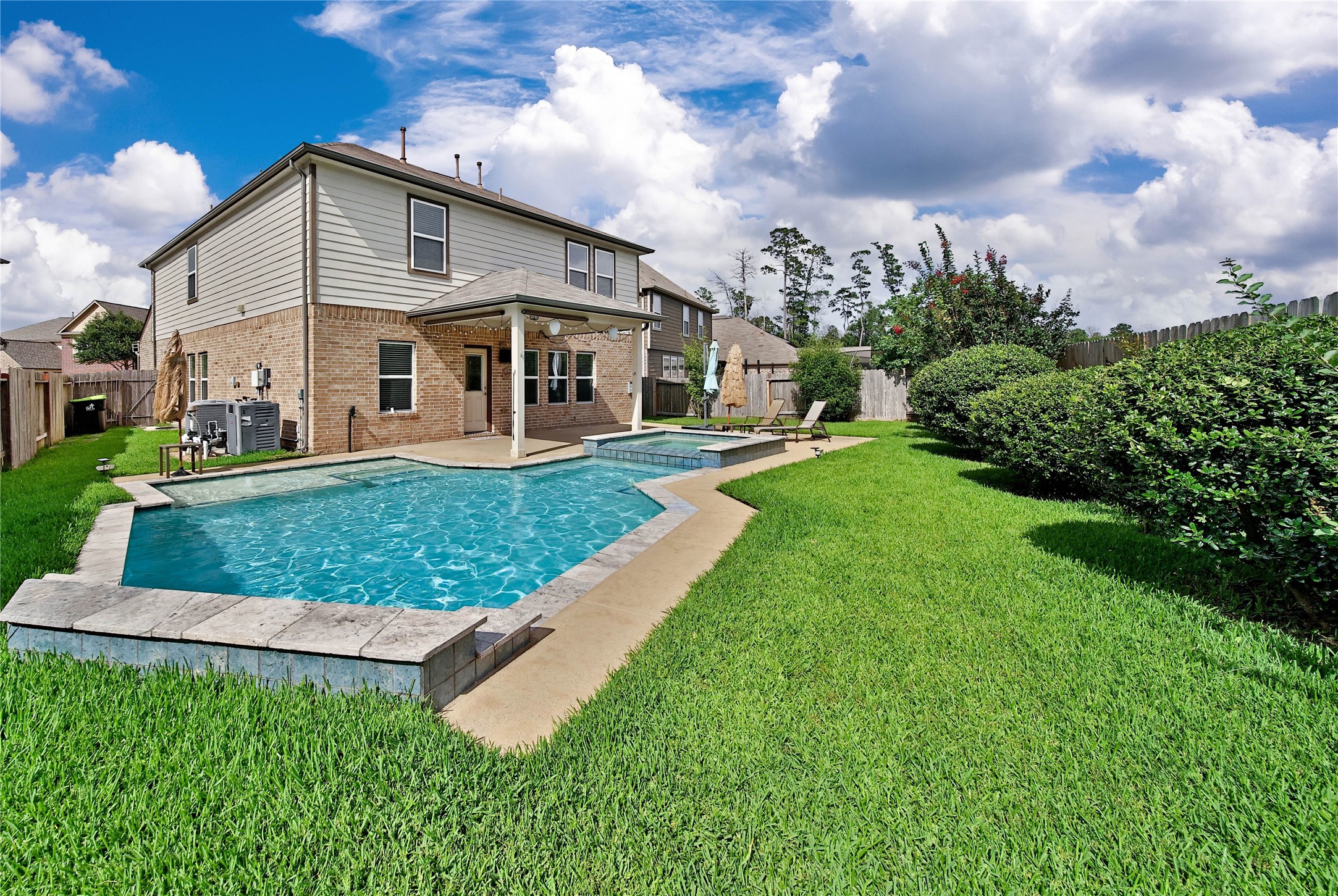 2672 Magnolia Fair Way Spring, TX 77386 - Photo 2 of 49 You'll love the tanning ledge and hot tub features of the pool that was customized for this backyard.