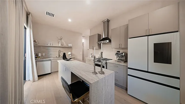 a kitchen with a sink a refrigerator and white cabinets