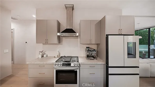 a kitchen with stainless steel appliances a refrigerator stove and white cabinets
