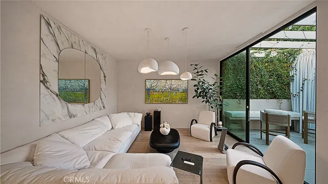 a living room with furniture large window and potted plants