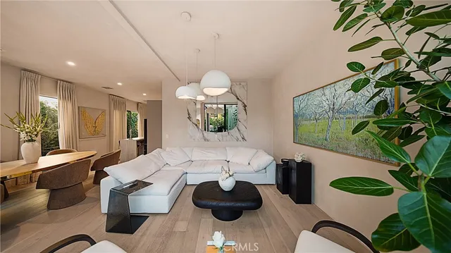a living room with furniture potted plant and a large window