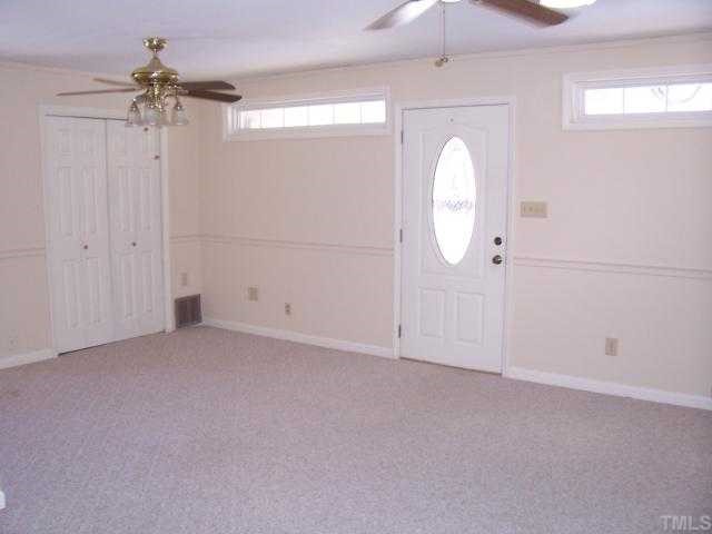 1308 Riverview Road Raleigh, NC 27610 - Photo 7 of 11 an empty room with a chandelier fan and a window