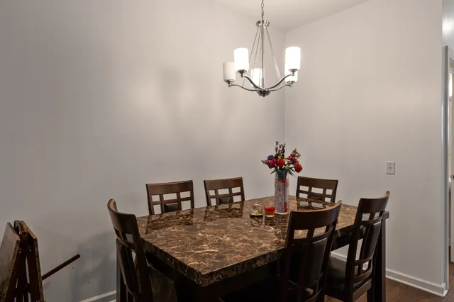 a kitchen with stainless steel appliances granite countertop a refrigerator a sink a stove a dining table and chairs