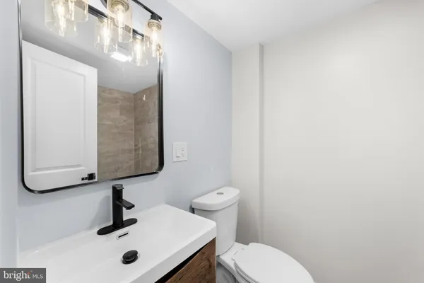 a bathroom with a sink a mirror and toilet