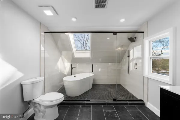 a bathroom with a toilet sink and a large mirror