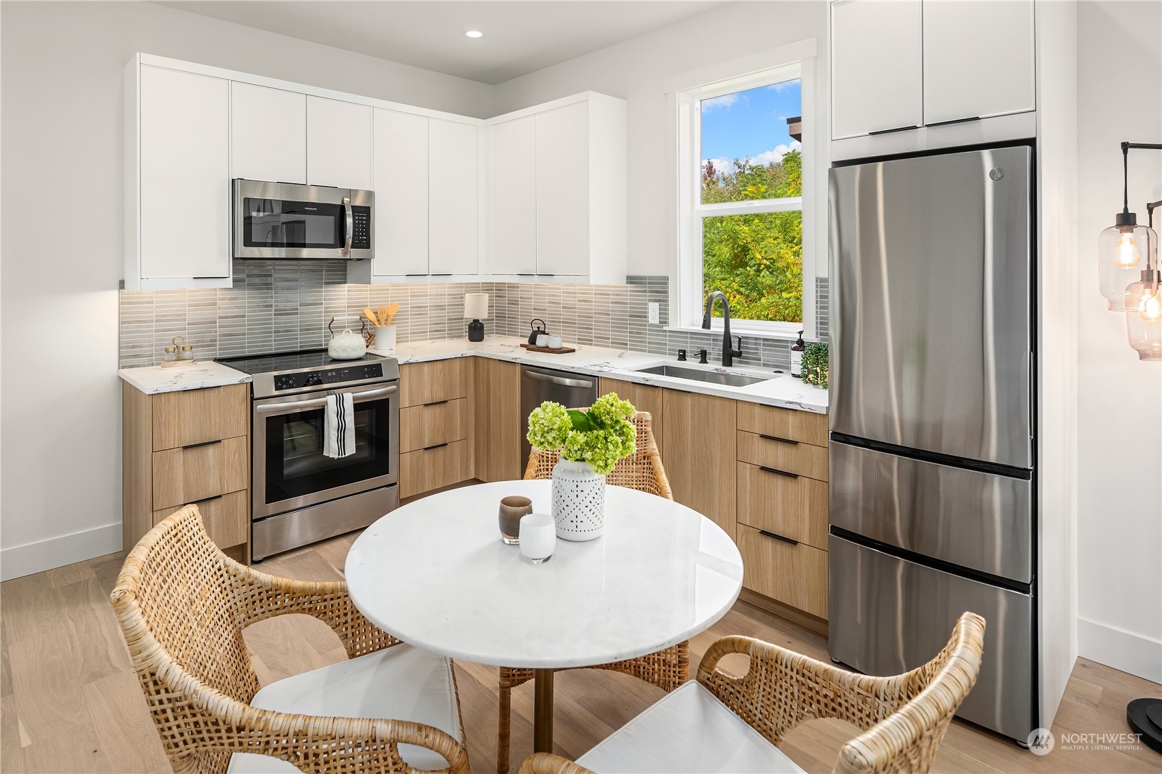 8809 B Wallingford Avenue North Seattle, WA 98103 - Photo 9 of 17 a kitchen with stainless steel appliances granite countertop a refrigerator a stove a sink a dining table and chairs