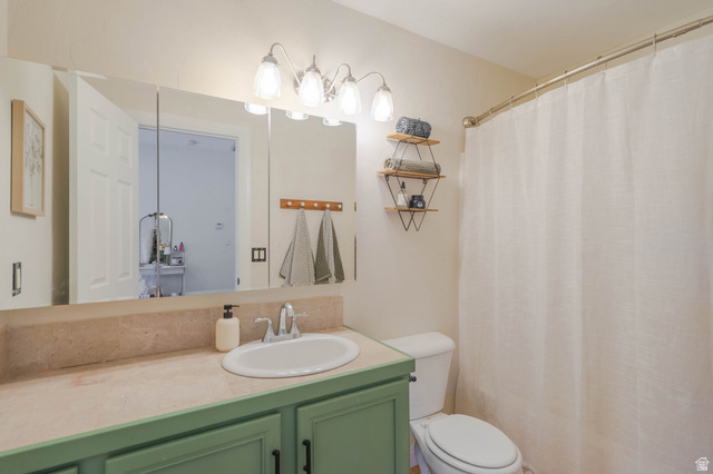 1504 Rome Way Apple Valley, UT 84737 - Photo 12 of 22 Bathroom featuring a vanity with a white oval sink, green cabinetry, and a light-toned countertop