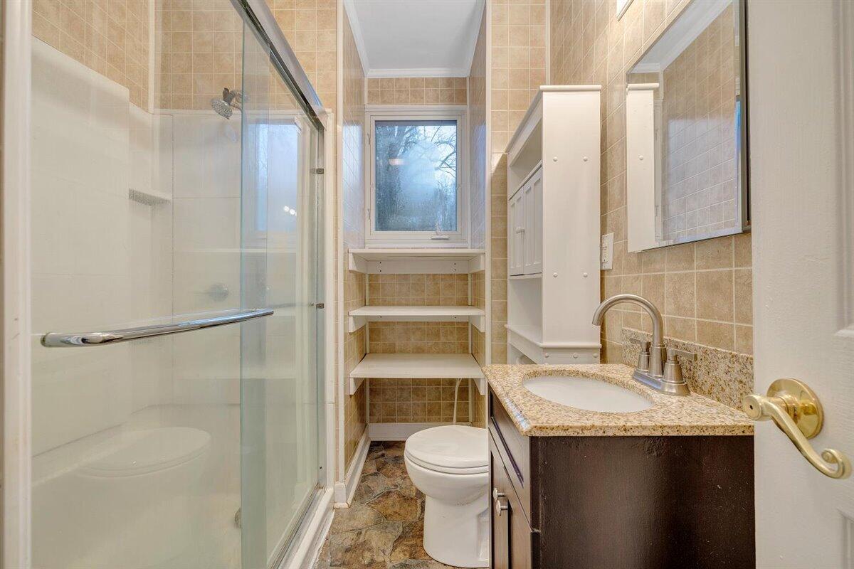 1115 Morgans Mill Road Goodview, VA 24095 - Photo 13 of 50 a bathroom with a granite countertop sink toilet and shower
