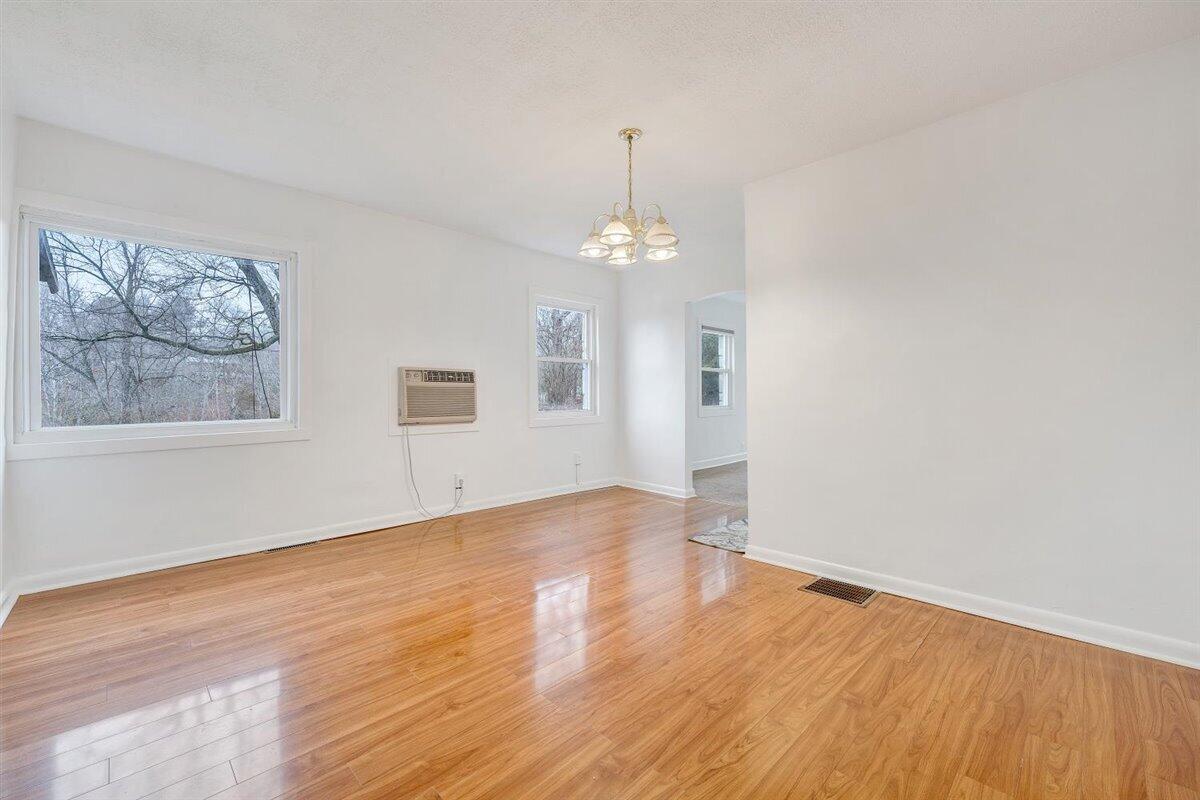 1115 Morgans Mill Road Goodview, VA 24095 - Photo 18 of 50 wooden floor in an empty room with a window