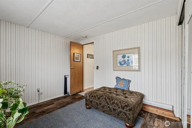 a bedroom with a bed and a painting on the wall