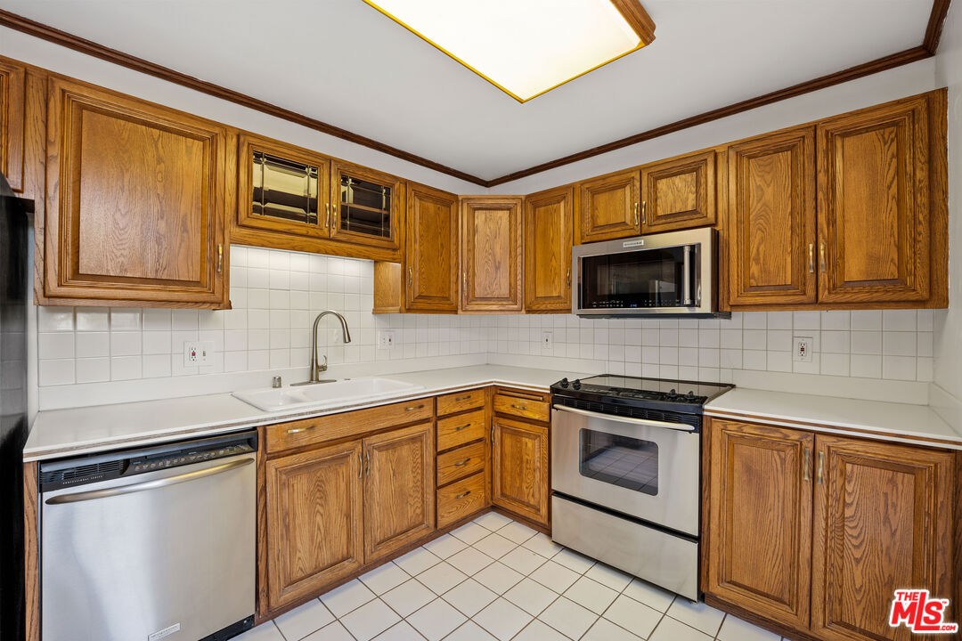 28288 Rey De Copas Lane Malibu, CA 90265 - Photo 21 of 44 a kitchen with stainless steel appliances granite countertop a sink stove and microwave