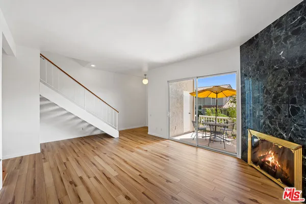 a view of empty room with wooden floor and fireplace
