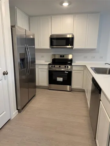 a kitchen with stainless steel appliances granite countertop a stove a refrigerator and a microwave