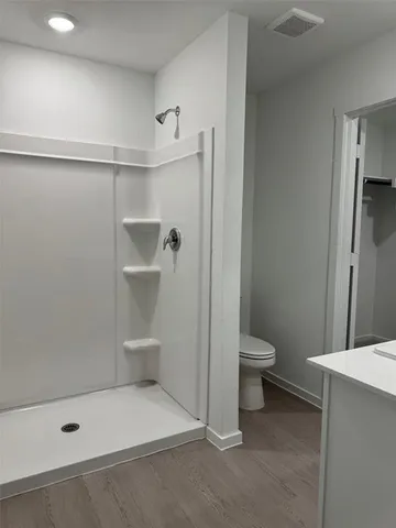 a bathroom with a toilet and a shower