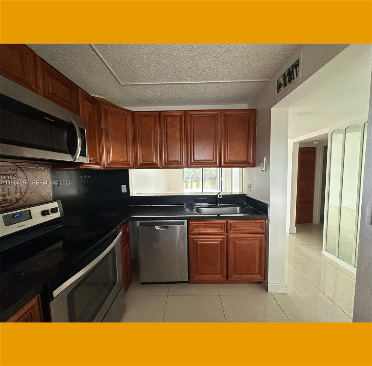 3396 Foxcroft Road, Unit 305 Miramar, FL 33025 - Photo 3 of 20 a kitchen with stainless steel appliances granite countertop a stove a sink and a microwave
