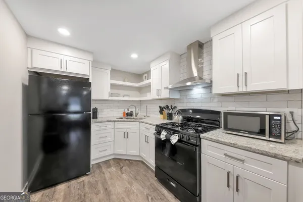 a kitchen with stainless steel appliances granite countertop a stove a refrigerator and a sink