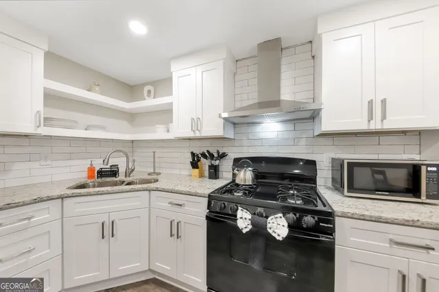 a kitchen with white cabinets and appliances