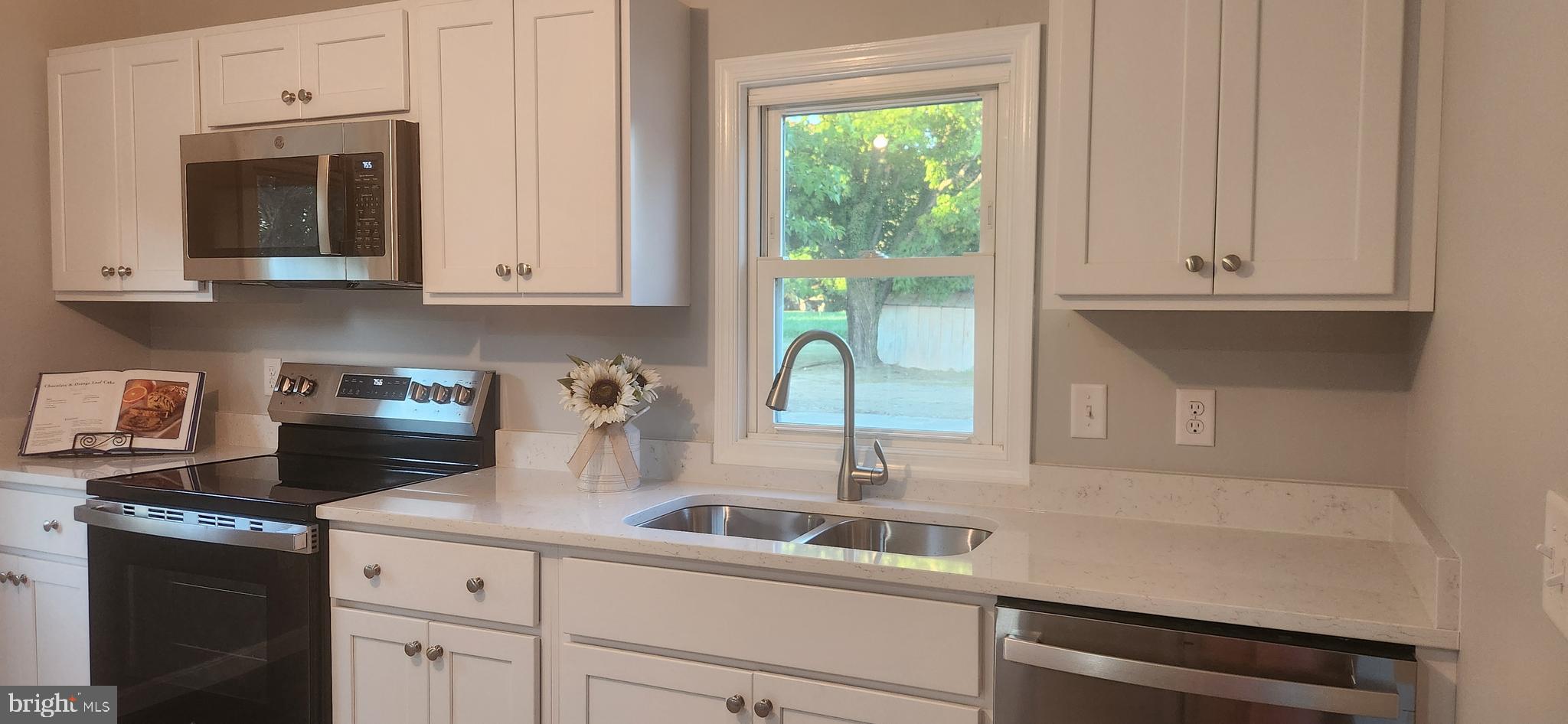 10819 Greensboro Road Denton, MD 21629 - Photo 11 of 27 a kitchen with stainless steel appliances granite countertop a sink a stove and a microwave
