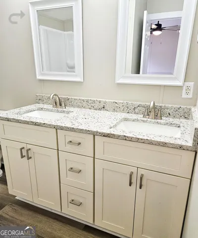a bathroom with a granite countertop sink a toilet and a mirror