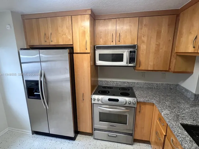 a kitchen with appliances a microwave and cabinets
