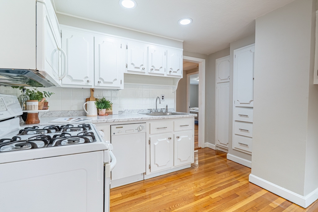 58 Gilman Street Springfield, MA 01118 - Photo 2 of 18 a kitchen with white cabinets and appliances
