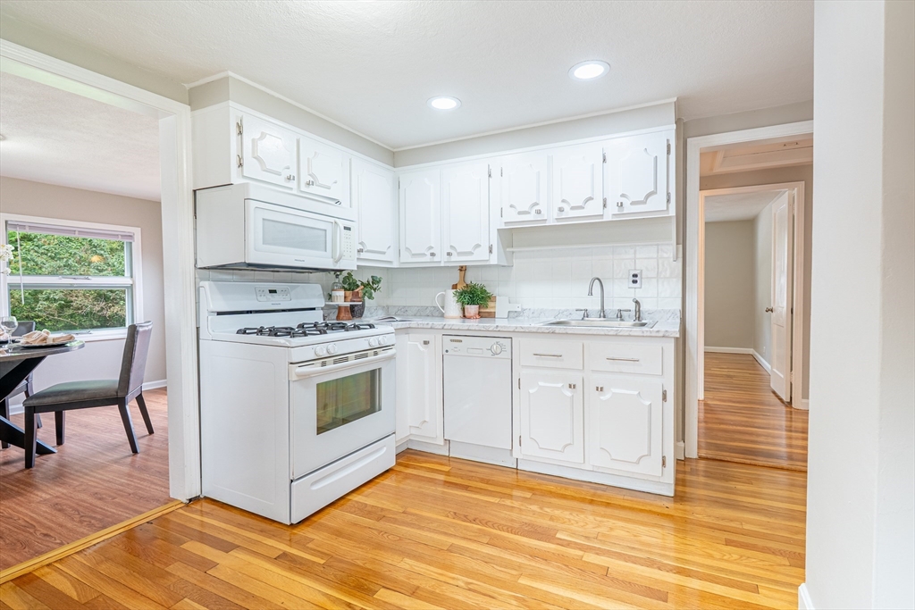58 Gilman Street Springfield, MA 01118 - Photo 3 of 18 a kitchen with white cabinets and white appliances