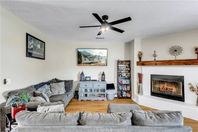 a kitchen with stainless steel appliances granite countertop a stove top oven a sink dishwasher and white cabinets with wooden floor