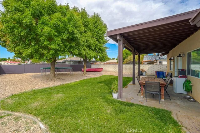 a view of a house with a backyard and a tree