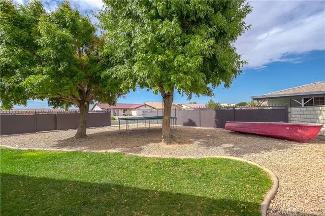 a view of a house with a yard and large tree