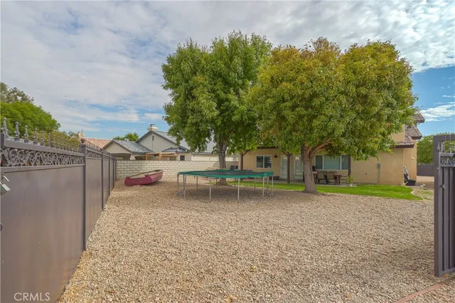 a view of backyard and wooden fence