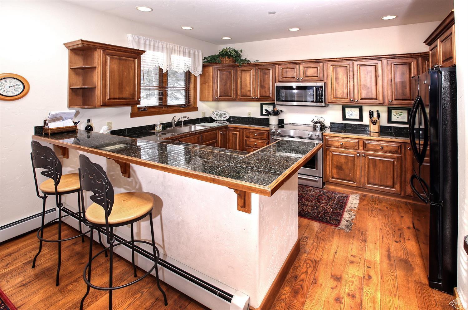 24 Clubhouse Circle Edwards, CO 81632 - Photo 4 of 17 a kitchen with stainless steel appliances granite countertop a sink a stove and a refrigerator
