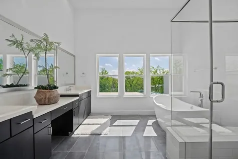 a spacious bathroom with a tub sink and mirror