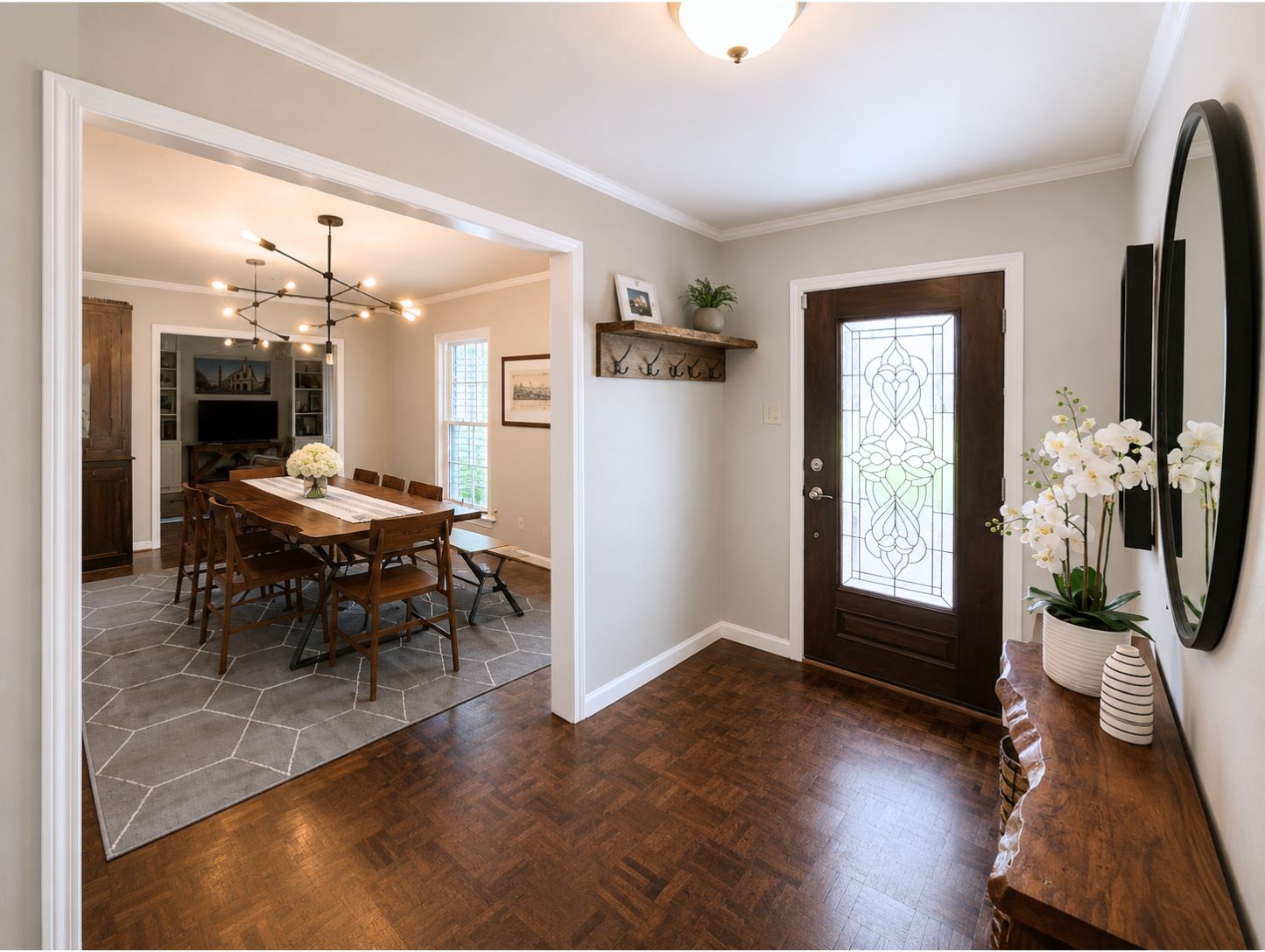 13047 Taylorcrest Road Houston, TX 77079 - Photo 4 of 23 Step inside to a welcoming foyer featuring rich wood flooring & a decorative glass front door, offering a seamless flow into the formal dining room & the living spaces beyond.