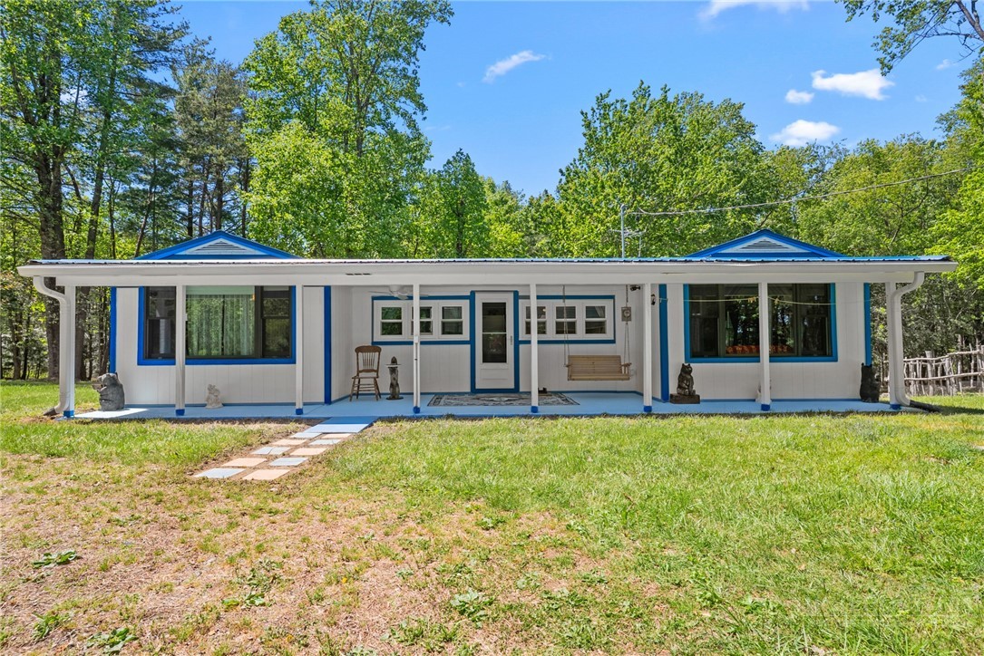 154 Folger Road Sparta, NC 28675 - Photo 2 of 37 a front view of a house with swimming pool and porch with furniture