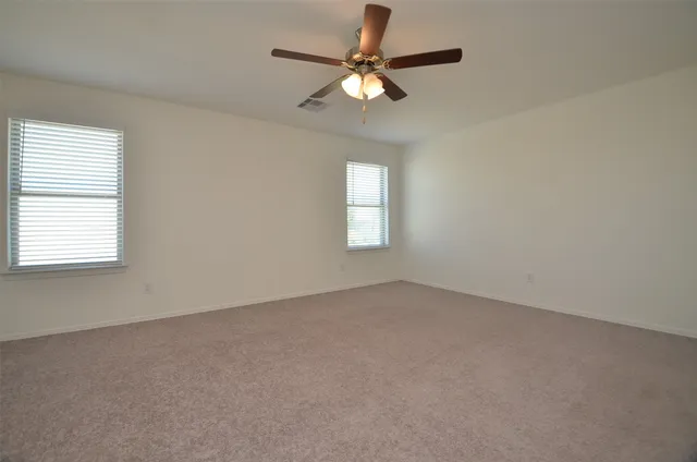 an empty room with a window and a fan