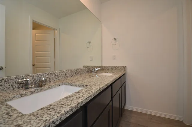 a bathroom with a granite countertop sink and a mirror