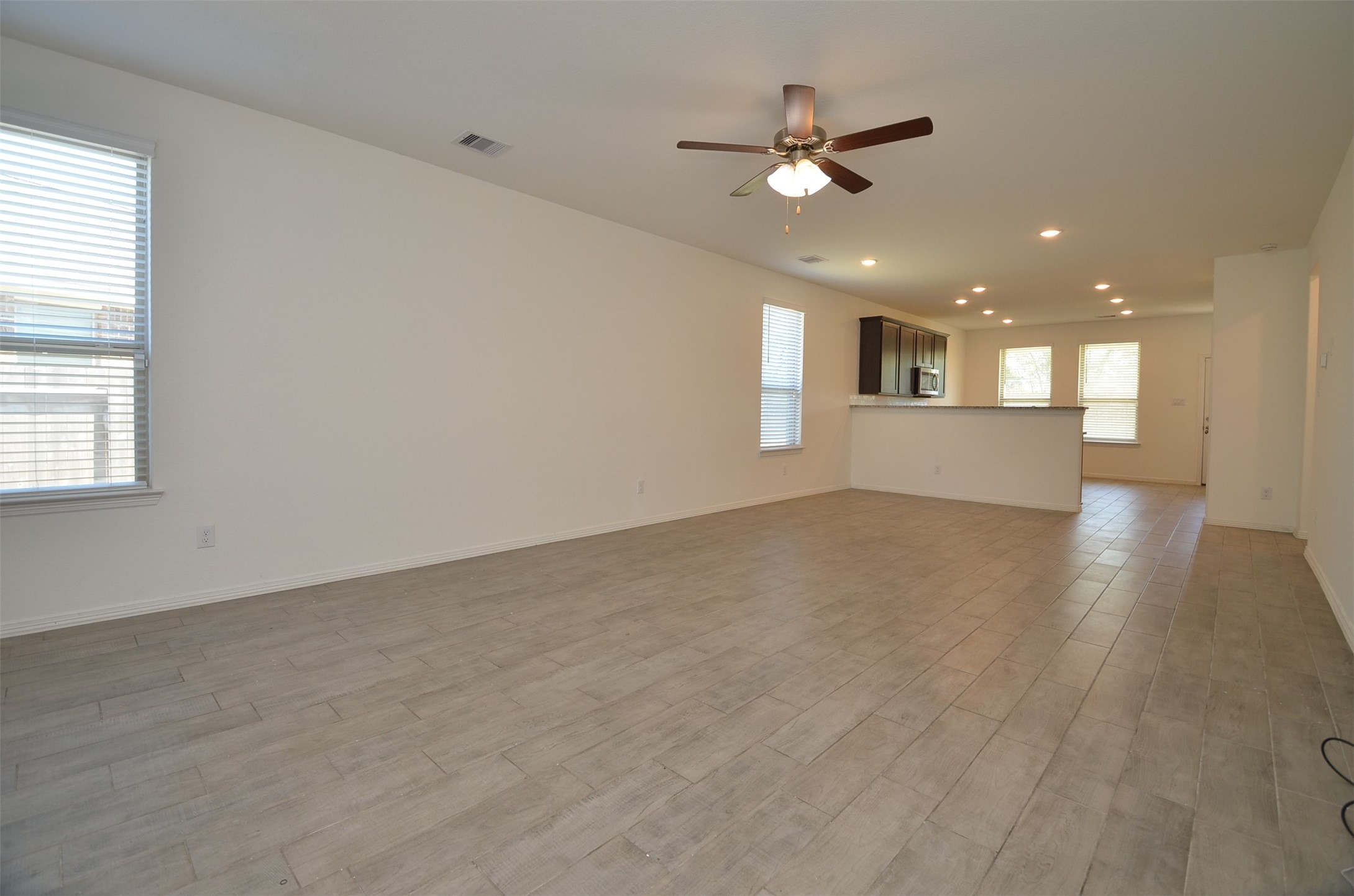 5602 Tabula Rasa Drive Katy, TX 77493 - Photo 6 of 38 an empty room with wooden floor ceiling fan and windows