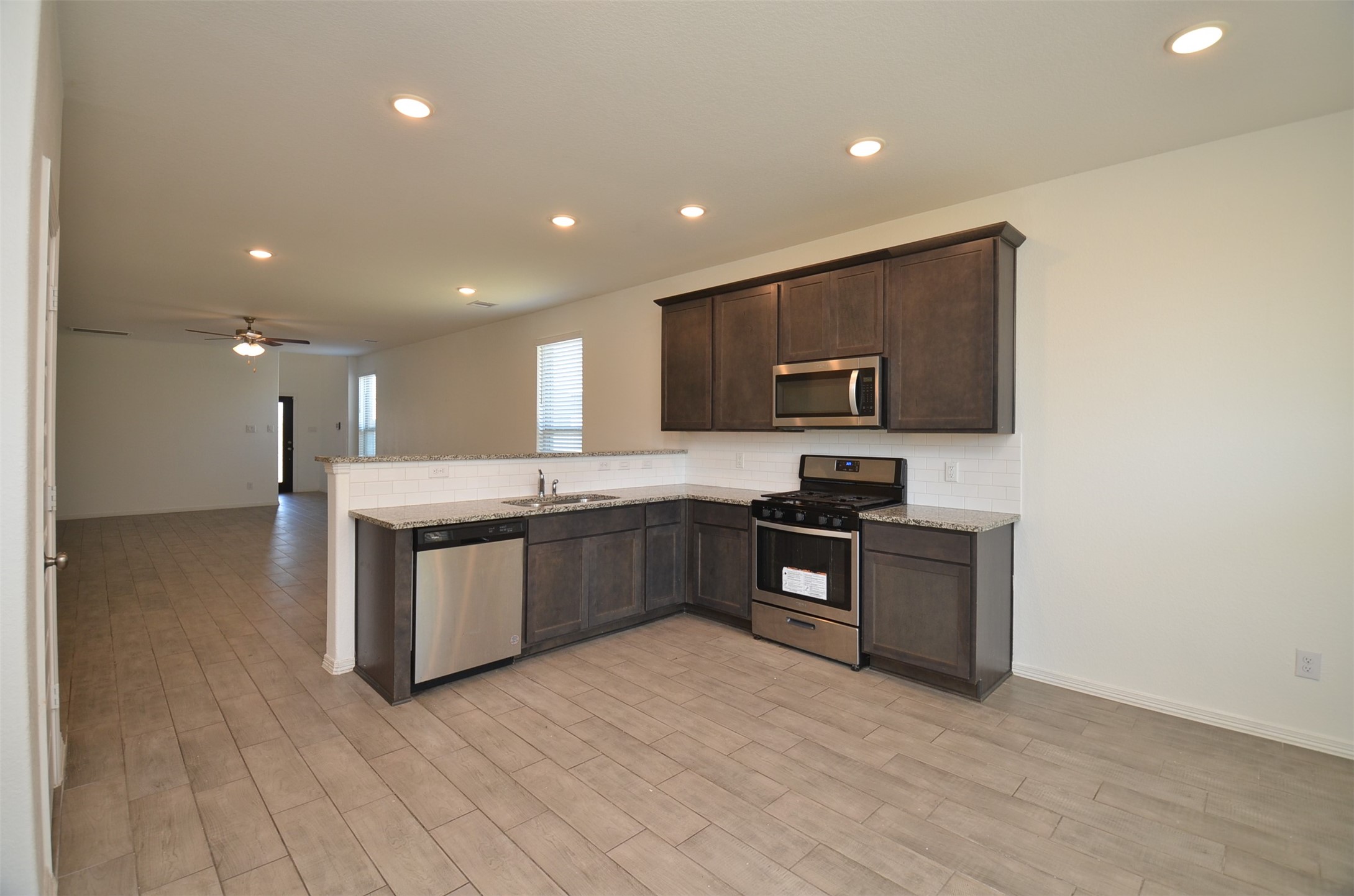 5602 Tabula Rasa Drive Katy, TX 77493 - Photo 8 of 38 a kitchen with stainless steel appliances granite countertop a stove top oven a sink dishwasher a microwave oven and a refrigerator with wooden floor