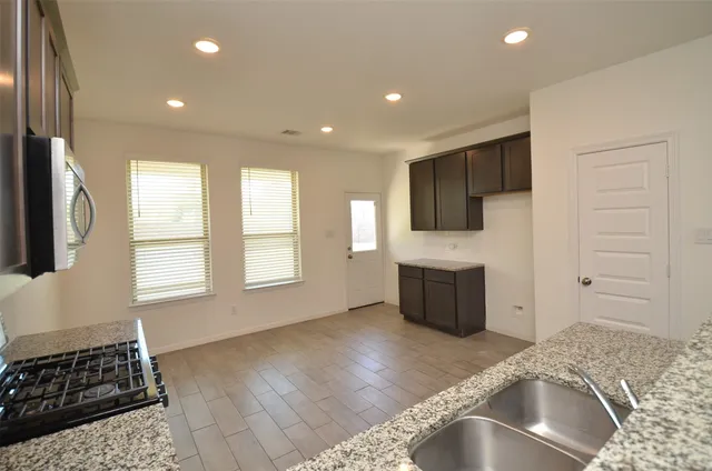 a kitchen with a refrigerator and a stove top oven