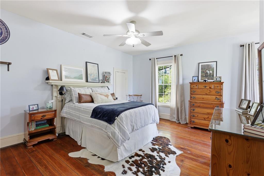 8075 Lakeview Road Statesboro, GA 30461 - Photo 29 of 46 a bedroom with a bed and wooden floor