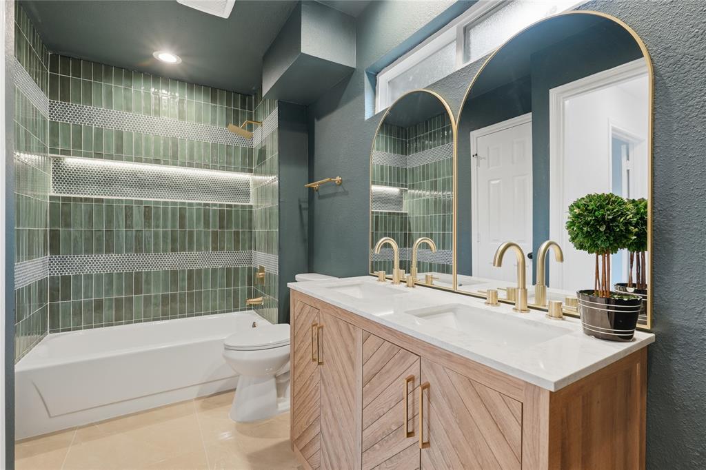 17118 Planters Row Addison, TX 75001 - Photo 13 of 18 Double vanity with dual undermount sinks, gold-finish fixtures, and arched mirrors