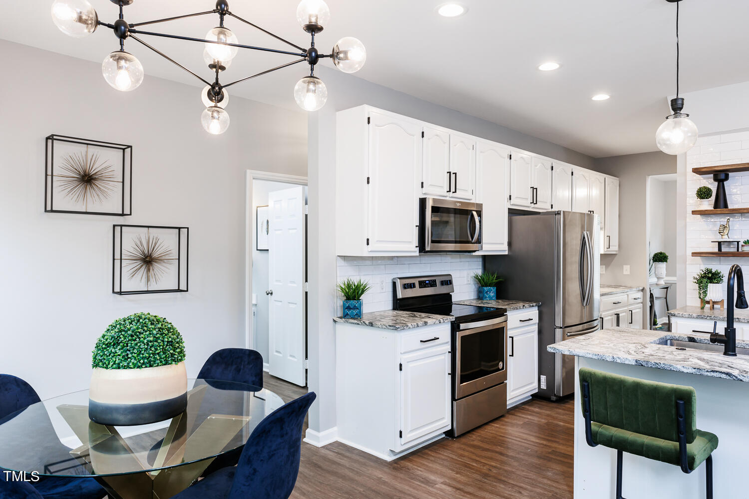 5120 Fairmead Circle Raleigh, NC 27613 - Photo 18 of 49 a kitchen with stainless steel appliances granite countertop a stove a refrigerator a kitchen island a dining table and chairs with wooden floor