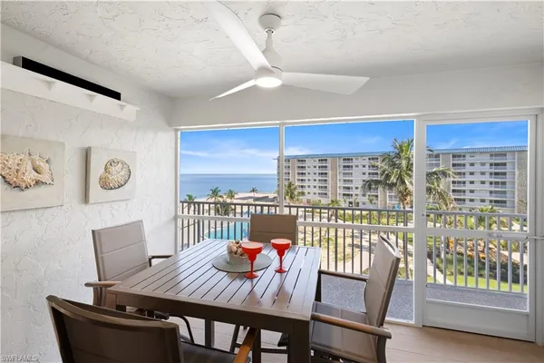 a view of a dining room with furniture a chandelier and wooden floor