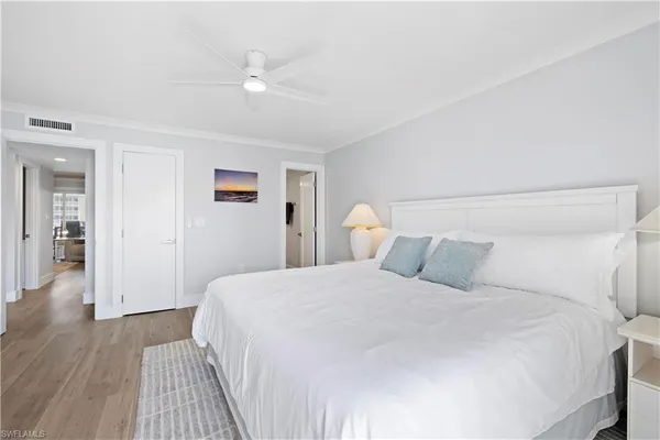a bedroom with a large bed and a ceiling fan
