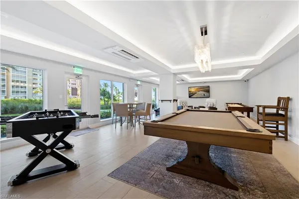 a living room with furniture pool table and a large window