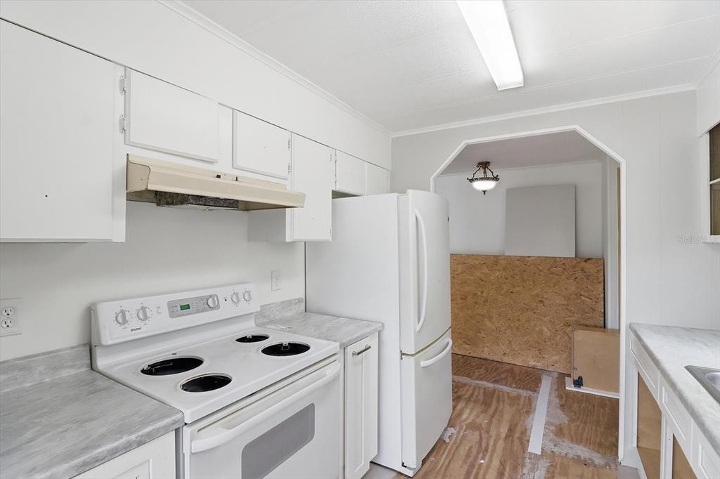 4950 West Mockingbird Street Homosassa, FL 34446 - Photo 37 of 47 a kitchen with a refrigerator a stove and white cabinets