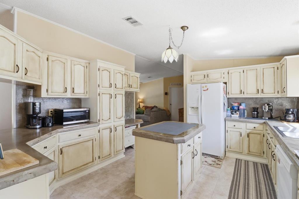 4950 West Mockingbird Street Homosassa, FL 34446 - Photo 6 of 47 a kitchen with white cabinets and stainless steel appliances