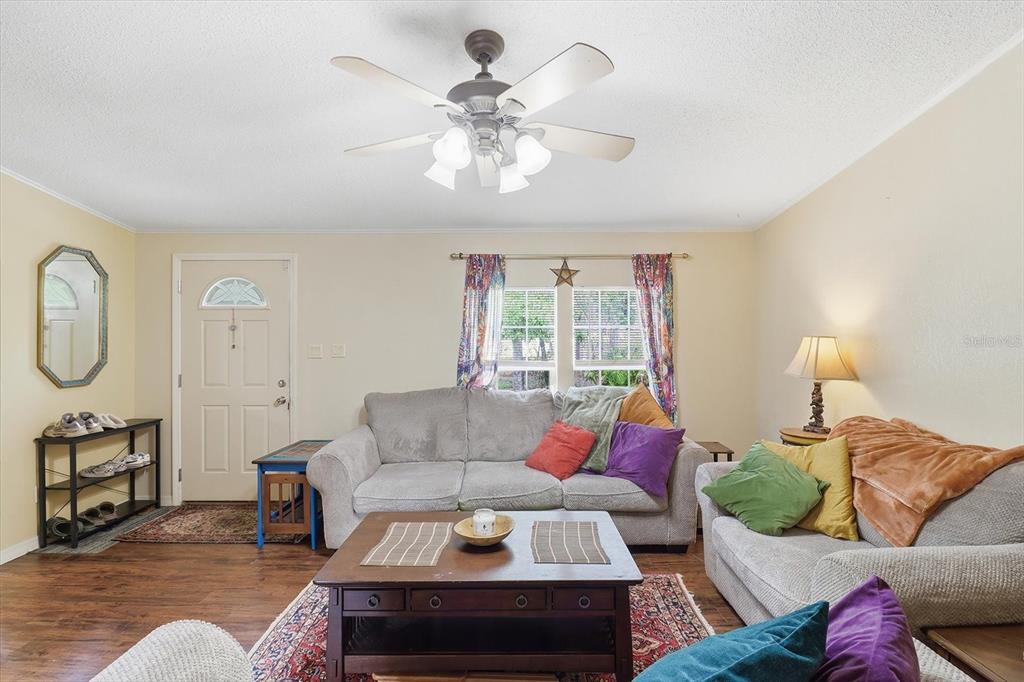 4950 West Mockingbird Street Homosassa, FL 34446 - Photo 8 of 47 a living room with furniture a chandelier fan and a window