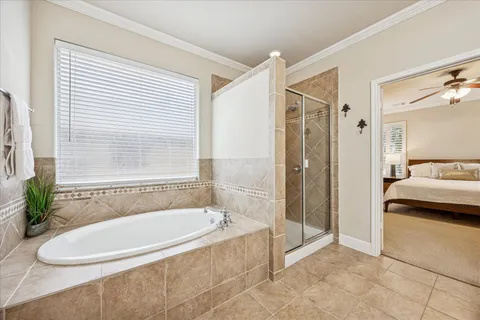a bathroom with a tub a window and a shower